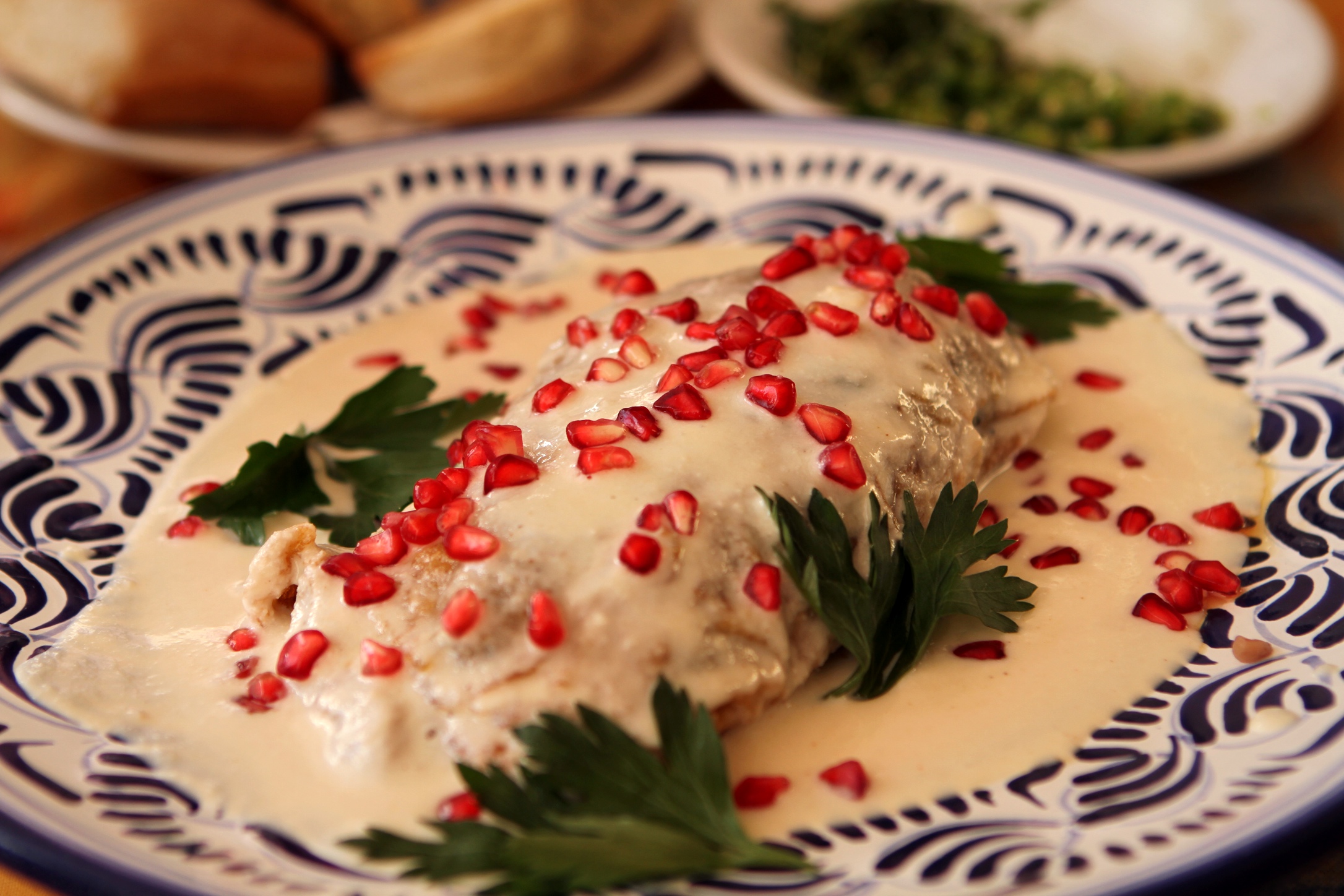 Chile en nogada servido con granada y salsa de nuez